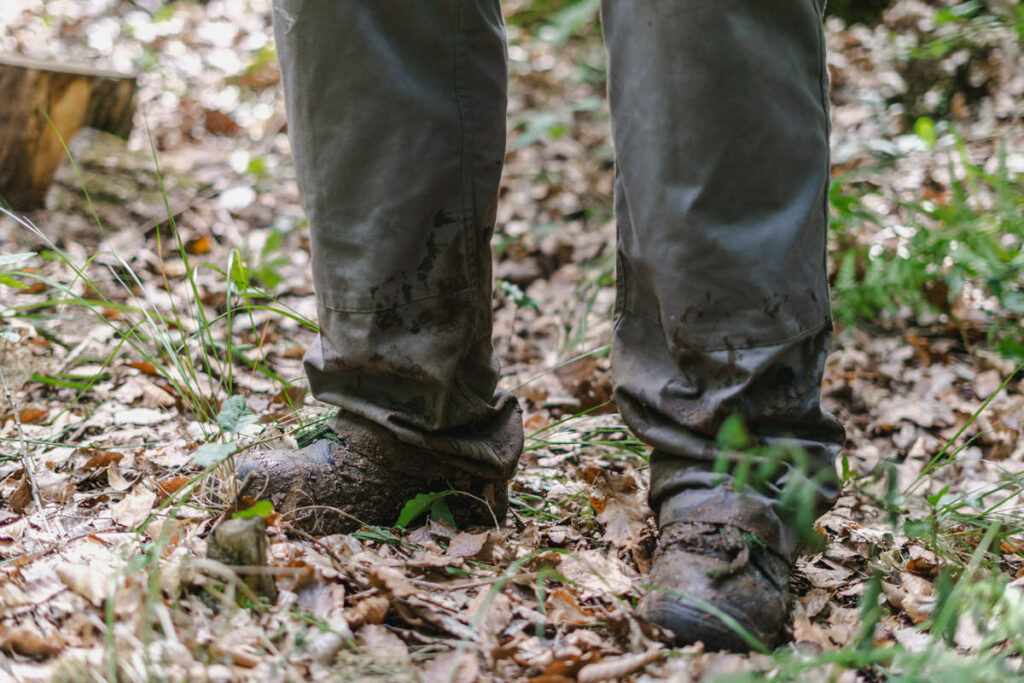 Schmutzige Schuhe und Füße im Wald